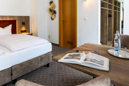 a bedroom with a bed and a book on a table at Bruckmayers Gästehaus in Pottenstein