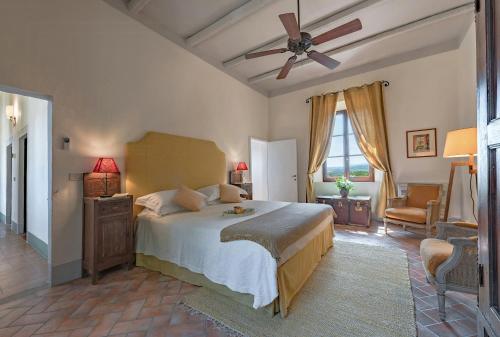 a bedroom with a bed and a ceiling fan at Tuscan Hamlet In Organic Wine Estate in Buonconvento