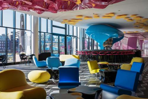 a lobby with colorful chairs and a fountain at nhow Berlin in Berlin