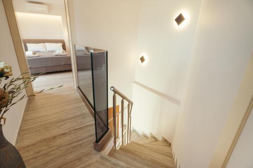 a stairway with a mirror and a bed in a room at DK Luxury Villas in Sivota