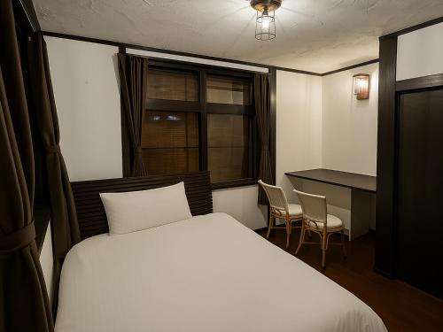 a bedroom with a bed and a desk and a table at Nagachibi ながちび in Miyako Island