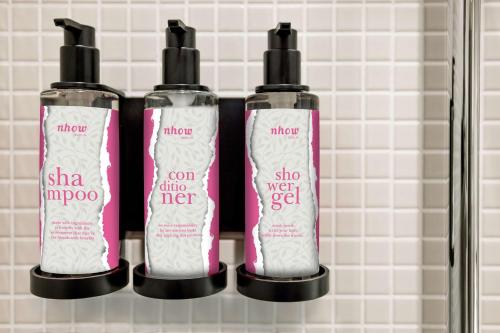 three bottles of hair products on a shelf at nhow Berlin in Berlin