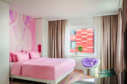 a pink bedroom with a pink bed and a window at nhow Berlin in Berlin