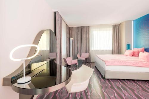 a bedroom with a bed and a table with a mirror at nhow Berlin in Berlin