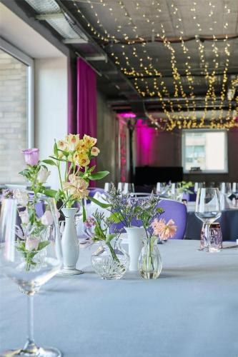 a table with vases of flowers on top of it at nhow Berlin in Berlin