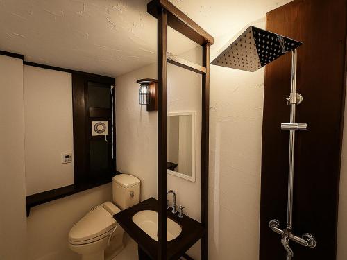 a small bathroom with a toilet and a sink at Nagachibi ながちび in Miyako Island