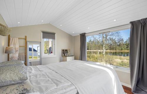 a bedroom with a bed and a large window at Lovely Farmhouse By Nidelva With Sauna And Hot Tub in Åmli