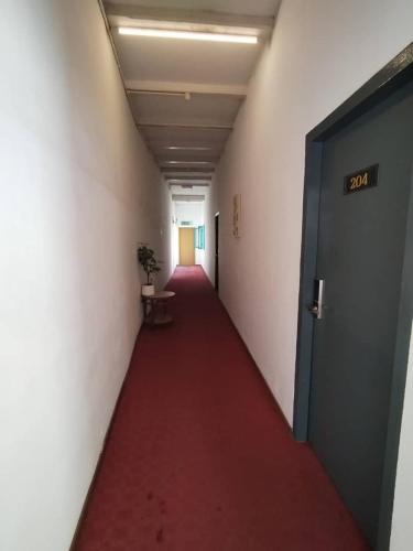 a long corridor with a red carpet in an office building at Heeren Street Boutique Hotel at Jonker Walk in Melaka