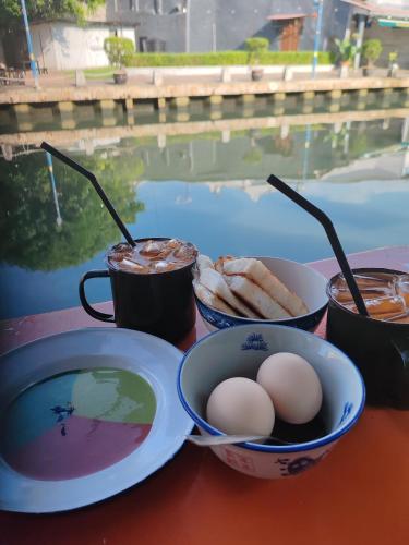 a table with bowls of food and eggs and drinks at Heeren Street Boutique Hotel at Jonker Walk in Melaka