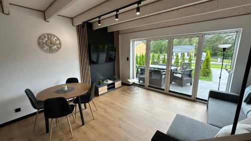 a living room with a table and a dining room at Moonlight Houses z banią w cenie !!! in Wielki Podleś