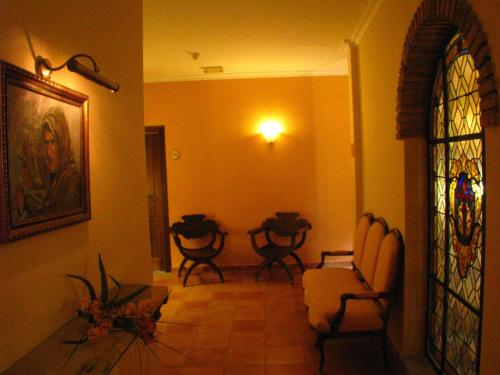 a living room with chairs and a stained glass window at Hotel Don Carlos Cáceres in Cáceres