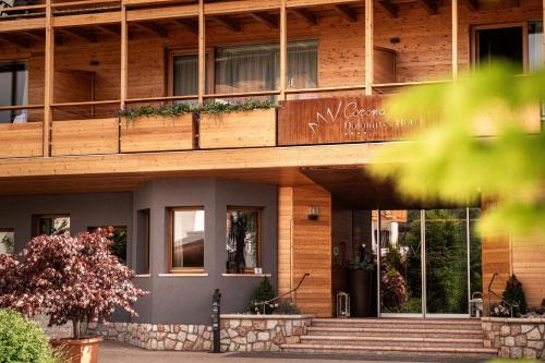 a wooden building with stairs in front of it at Corona Dolomites Hotel in Andalo