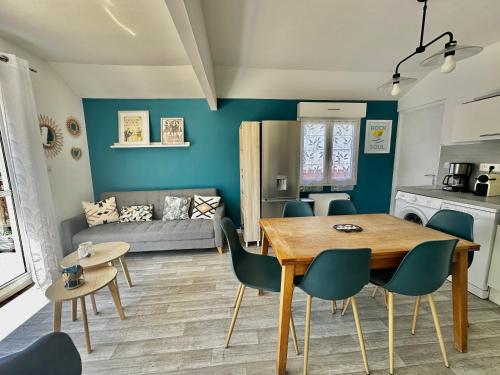 une cuisine et un salon avec une table et des chaises dans l'établissement Captain's Quarters - Maison en bord de plage, à Saint-Côme-de-Fresné