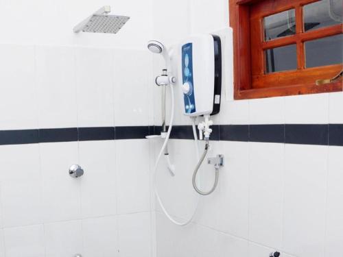 a shower in a bathroom with a phone on the wall at Sihilro Regency Hotel in Udawalawe