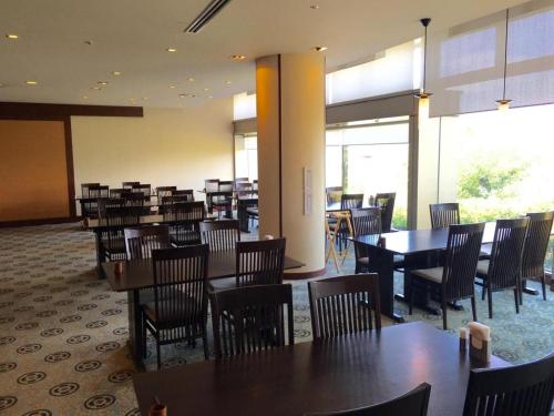 a dining room with tables and chairs in a restaurant at Hotel Harvest Nankitanabe in Tanabe