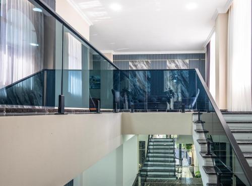 a staircase with glass railings in a building at Novo Sky Hotel in Baku