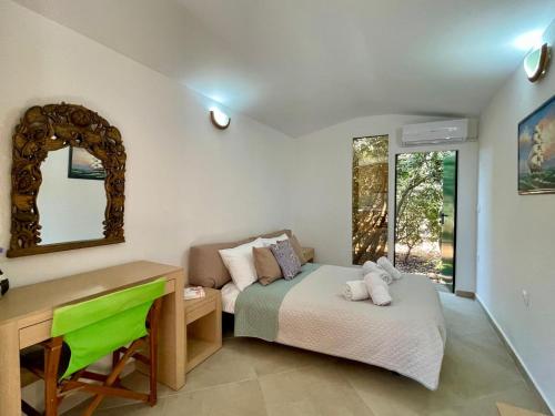 a bedroom with a bed and a desk and a mirror at The Secret Nest in Limín Khersonísou