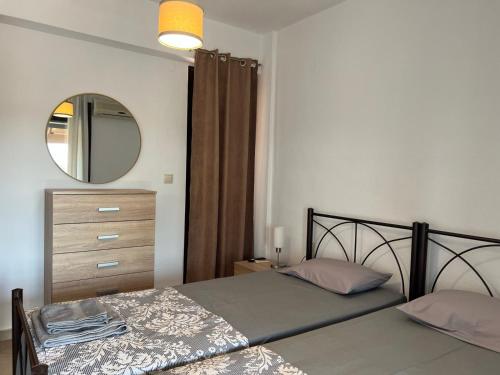 a bedroom with a bed with a mirror and a dresser at Villa-Alpha in Kassandria