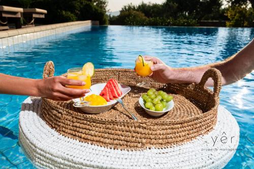 a person holding a picnic basket with fruit and juice at 6BR Villa with Private Pool, 4 Baths & Garden -PADMA in Angairiá