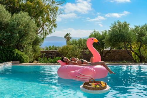 a woman in a pink flamingo raft in a pool at 6BR Villa with Private Pool, 4 Baths & Garden -PADMA in Angairiá