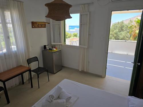 a bedroom with a bed and a table and a window at Oasis in Kamarai