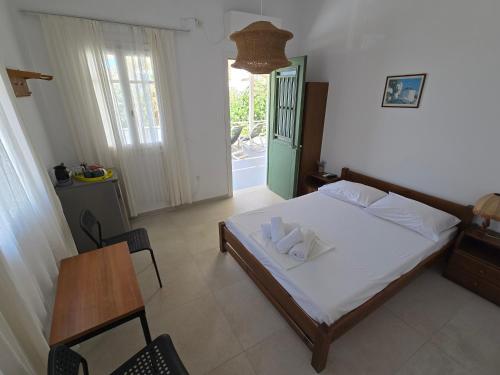 a bedroom with a bed and a table and a window at Oasis in Kamarai