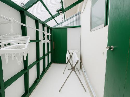 a green and white room with a sink and a tripod at Nagachibi ながちび in Miyako Island