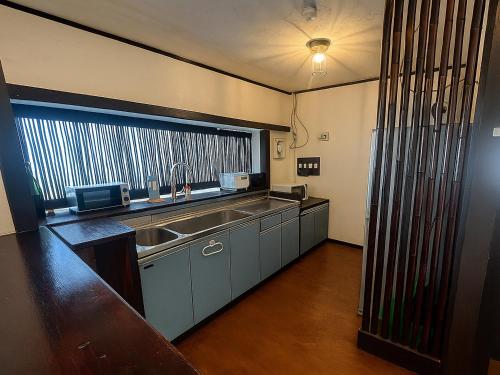 a kitchen with a sink and a large window at Nagachibi ながちび in Miyako Island