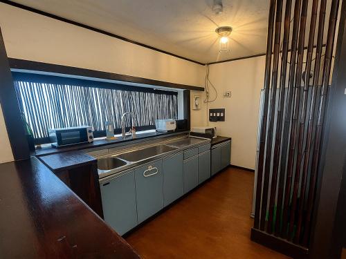 a kitchen with a sink and a large window at Nagachibi ながちび in Miyako Island