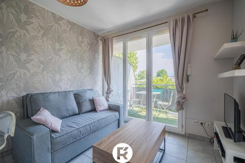 a living room with a couch and a table at R'Apparts T2 L'Echappée Douce in Sassenage