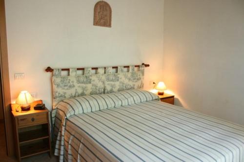 ルチニャーノにあるVilla La Coloniaのベッドルーム1室(ベッド1台、ナイトスタンド2台、ランプ2つ付)
