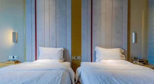 two beds sitting next to each other in a room at Lavande Hotels Suzhou Railway Station in Suzhou