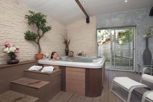 twee personen in een bad in een kamer bij Camping Officiel Siblu Domaine de Soulac in Soulac-sur-Mer