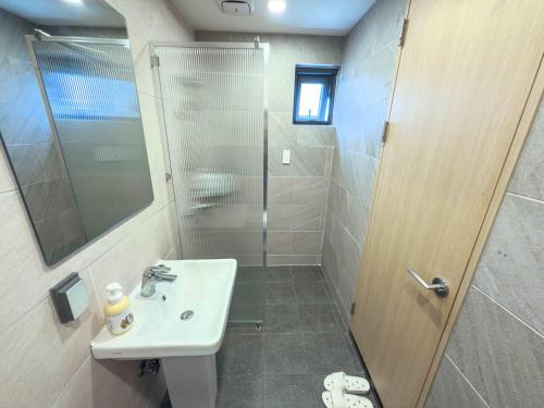 a bathroom with a sink and a shower at Guest House Brick in Jeju