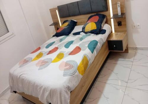 un letto con cuscini colorati in una stanza di Le Conviviall a Yaoundé