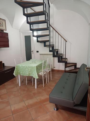 a living room with a table and a spiral staircase at Portico Ratti in Riva Ligure