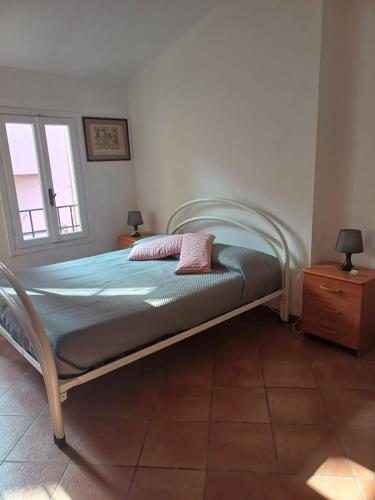 a bed sitting in a room with a window at Portico Ratti in Riva Ligure