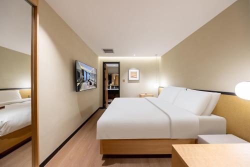 a hotel room with a bed and a mirror at Beijing Tangfu Nanluoguxiang Wang Fu Jing Forbidden City Snack Street Hotel,1 stop walking to airport express,3 stop to tiananmen&Free Laundry Dry Service and Free Afternoon Tea &professional Free Tour Ticket Service with English Speaking Staff in Beijing