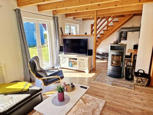 a living room with a couch and a tv at Ferienhaus Meeresrauschen am Salzhaff - ABC582 in Boiensdorf