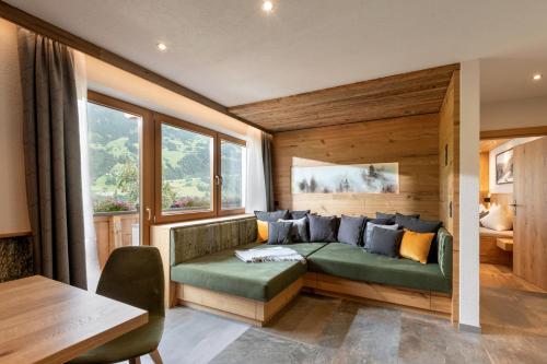 a bedroom with a green couch in a room with windows at Apartments Fleidl in Zell am Ziller