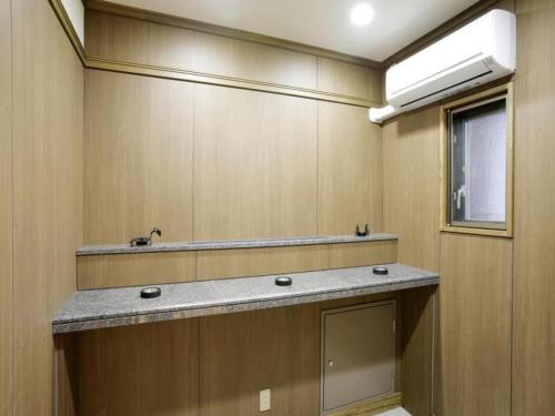 a bathroom with a sink and a mirror at Hotel Sunoak Kashiwanoha in Kashiwa