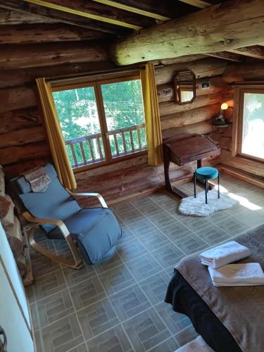 a room in a log cabin with a bed and a desk at chambre d hôtes La cabane du Haouré in Haget