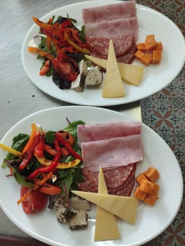 two plates of food with meat and vegetables and cheese at Central 214 Boutique Hotel in Hamrun