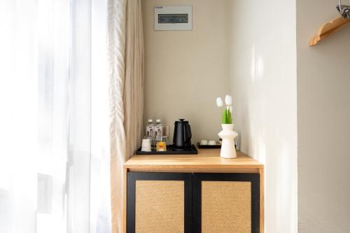a table with a coffee maker on it next to a window at Beijing Tangfu Nanluoguxiang Wang Fu Jing Forbidden City Snack Street Hotel,1 stop walking to airport express,3 stop to tiananmen&Free Laundry Dry Service and Free Afternoon Tea &professional Free Tour Ticket Service with English Speaking Staff in Beijing