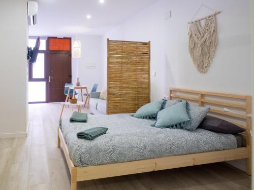 a bedroom with a large bed with blue pillows at Boho Beach Flats in Valencia