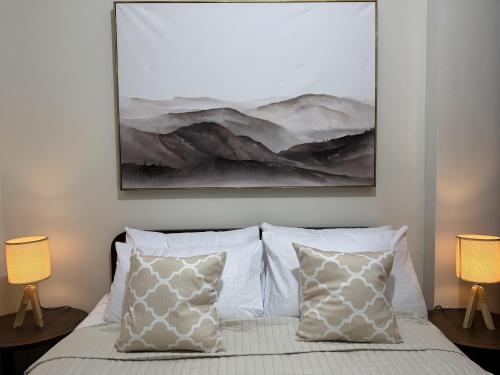 a bedroom with a painting above a bed with pillows at Hiraya Solana in Boracay