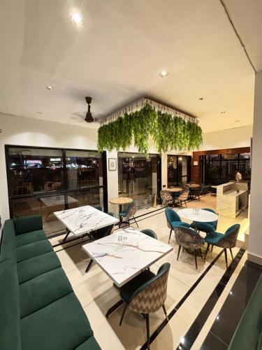 a restaurant with tables and chairs and vines at Hotel Royal Palm Inn in Faizābād