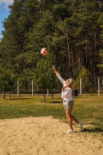 a woman playing with a volley ball in a field at Moje Miejsce Jura in Lgota Murowana