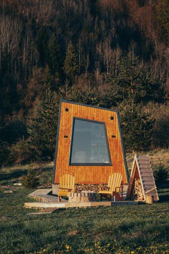Una pequeña casa con un televisor de pantalla grande y dos sillas. en Tiny Glamp House - DANGUBA by IGLENA, en Kupres