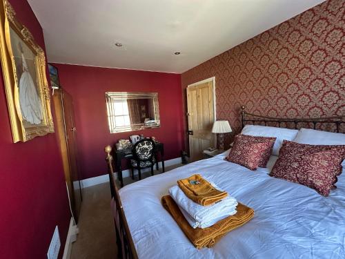 a bed in a red bedroom with a tray on it at Hitchcock House in Hastings